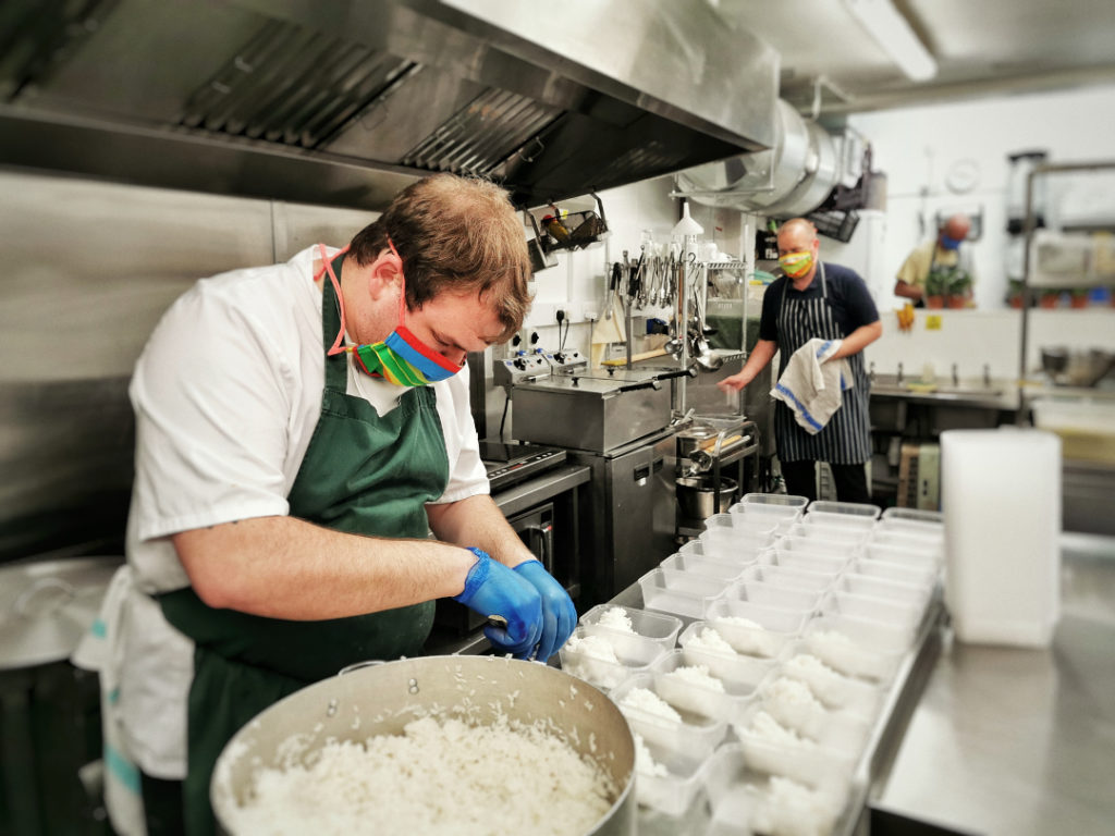 Volunteers wearing masks working in the coop brum kitchen